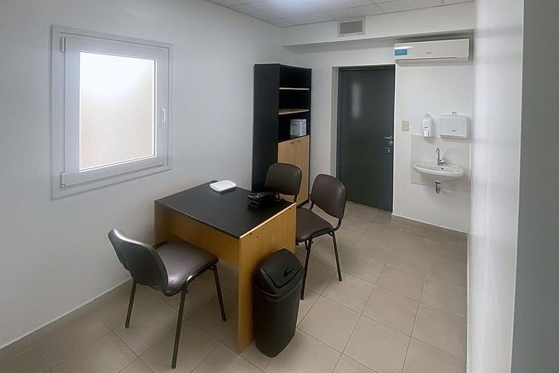 Consultorio con escritorio, sillas y ventana